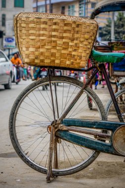 Geleneksel bambu sepetli eski bir bisiklet Mandalay, Myanmar 'da eski bir caddede park edilmiştir..