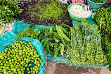 Selling fresh vegetables in a traditional market in Mandalay, Myanmar.