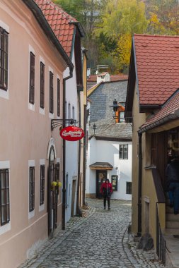 Krumlov, Çek - 24 Ekim 2025. Krumlov, Güney Bohemya, Çek Cumhuriyeti manzaralı, ikonik kale kulesi ve nehir boyunca kırmızı çatılı binalar.