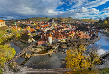 Krumlov, Güney Bohemya, Çek Cumhuriyeti manzaralı, ikonik kale kulesi ve nehir boyunca kırmızı çatılı binalar.