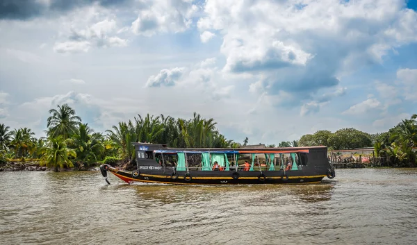 Tho 'm, Vietnam - 16 Aralık 2022. Geleneksel ahşap tekne Mekong Nehri 'nde Tho, Mekong Delta, Güney Vietnam' da, yemyeşil tropikal manzara ve sakin sularla çevrili..