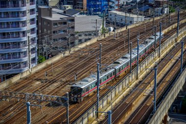 Kanazawa, Japonya - 1 Mayıs 2023. Kanazawa City, Japonya 'dan geçen elektrikli bir trenin bulunduğu raylar..