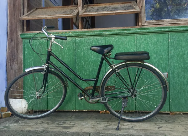 Old bike against the wall at home — Zdjęcie stockowe