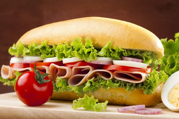 Velký sendvič s šunkou, sýrem a zeleninou — Stock fotografie