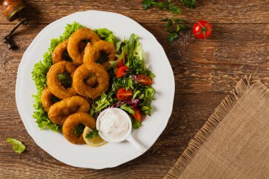 Kızarmış kalamar halkaları ve salata. Üst görünüm.