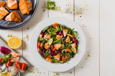 Izgara somon parçalı lezzetli salata. Üst Manzara. Beyaz tahta arkaplan.