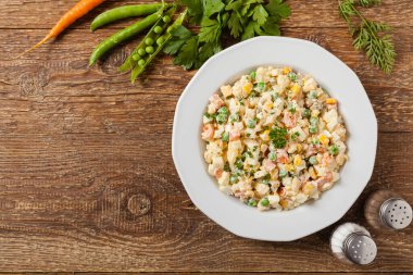 Mayonezli sebzeli geleneksel salata. Ahşap arka plan. Üst görünüm.