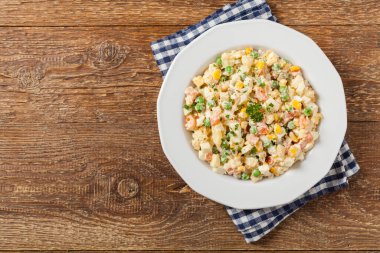 Mayonezli sebzeli geleneksel salata. Ahşap arka plan. Üst görünüm.