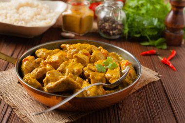 Körili tavuk sosu. Tavada servis edilmiş. Ön manzara. Doğal ahşap zemin.