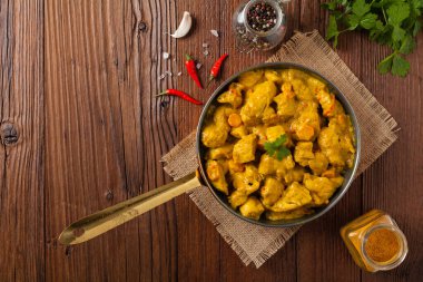 Körili tavuk sosu. Tavada servis edilmiş. Üst Manzara. Doğal ahşap zemin.