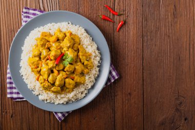 Körili tavuk sosu. Pirinçle servis edilmiş. Üst Manzara. Doğal ahşap zemin.