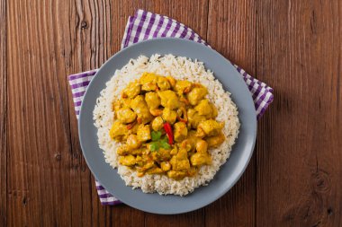 Körili tavuk sosu. Pirinçle servis edilmiş. Üst Manzara. Doğal ahşap zemin.