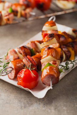 Sosisli, pastırmalı ve sebzeli ızgara şiş. Ön manzara. taş arkaplan. 