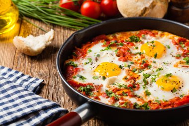 Shakshouka, domates sosunda haşlanmış yumurta, acı biber, soğan. Ön görünüm. 