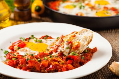 Shakshouka, domates sosunda haşlanmış yumurta, acı biber, soğan. Ön görünüm. 