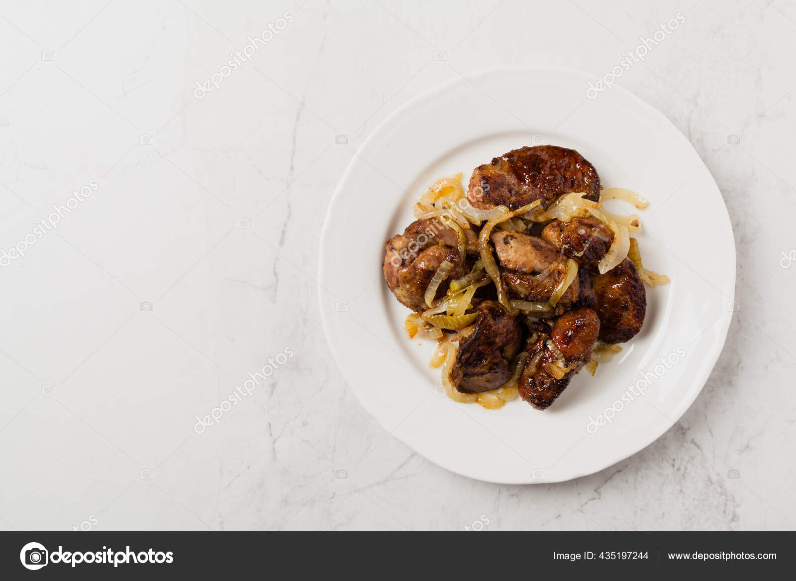 Fígado de frango frito com cebola e ervas fundo preto vista superior