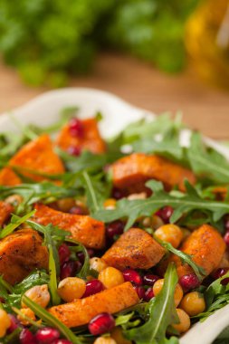 Mercimek, nar ve roketli tatlı patates salatası. Ön manzara. Doğal ahşap zemin.