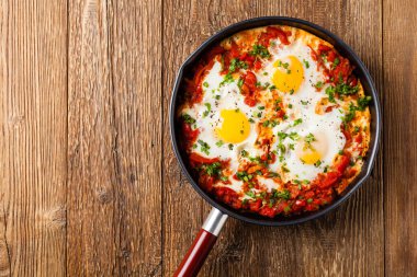 Shakshouka, domates sosunda haşlanmış yumurta, acı biber, soğan. Üst görünüm. 