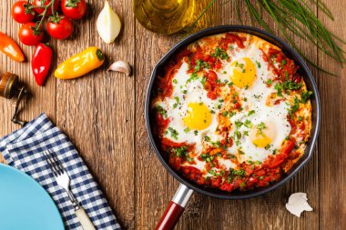 Shakshouka, domates sosunda haşlanmış yumurta, acı biber, soğan. Üst görünüm. 