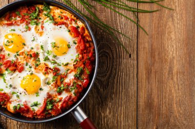 Shakshouka, domates sosunda haşlanmış yumurta, acı biber, soğan. Üst görünüm. 