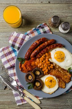 Tam İngiliz kahvaltısı, sosis, mantar, fasulye ve sahanda yumurta. Üst görünüm. 