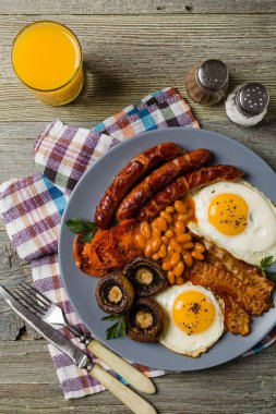 Tam İngiliz kahvaltısı, sosis, mantar, fasulye ve sahanda yumurta. Üst görünüm. 