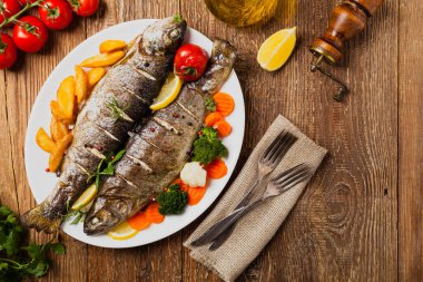 Izgara alabalık. Fırında patatesle servis edilir. Üst görünüm. 