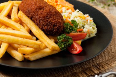 Tavuk Kiev (de Volaille pirzolası) patates kızartması ve salata ile. Ön görünüm.