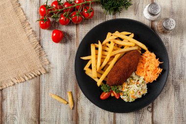 Tavuk Kiev (de Volaille pirzolası) patates kızartması ve salata ile. Üst görünüm.