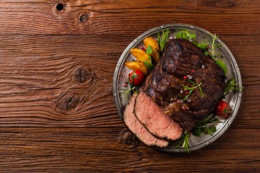 Kızarmış göğüs eti. Kırsal tarzda, doğal ahşap arka plan. Karanlık stil. Üst Manzara. Düz yatıyordu. 