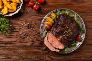 Kızarmış göğüs eti. Kırsal tarzda, doğal ahşap arka plan. Karanlık stil. Üst Manzara. Düz yatıyordu. 