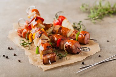 Sosisli, pastırmalı ve sebzeli ızgara şiş. Ön manzara. taş arkaplan. 