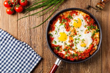 Shakshouka, domates sosunda haşlanmış yumurta, acı biber, soğan. Üst görünüm. 