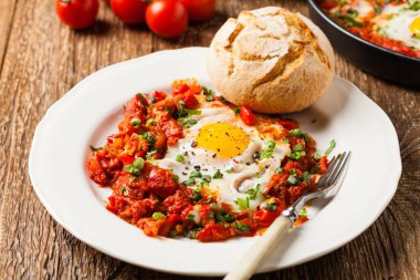 Shakshouka, domates sosunda haşlanmış yumurta, acı biber, soğan. Ön görünüm. 