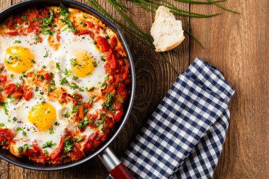 Shakshouka, domates sosunda haşlanmış yumurta, acı biber, soğan. Üst görünüm. 
