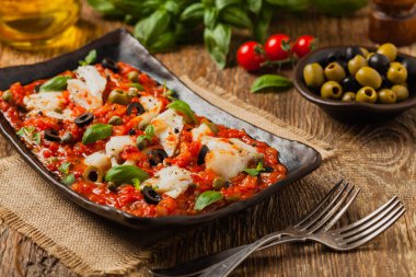 İtalyan usulü morina, domatesli zeytin ve kapari. Ön görünüm.