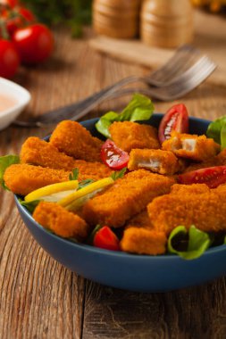 Mavi kasede salatalı balık çubukları. Ön görünüm.