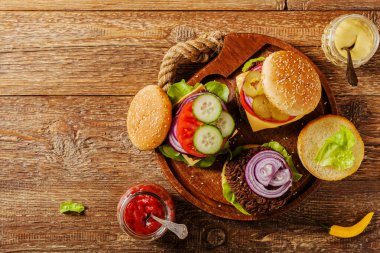Ev yapımı, peynirli ve sebzeli sığır burger. Üst görünüm.
