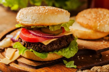 Ev yapımı, peynirli ve sebzeli sığır burger. Ön görünüm.