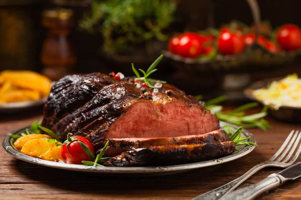 Roasted brisket. Rustic style, natural wooden background. Dark style. Front view.