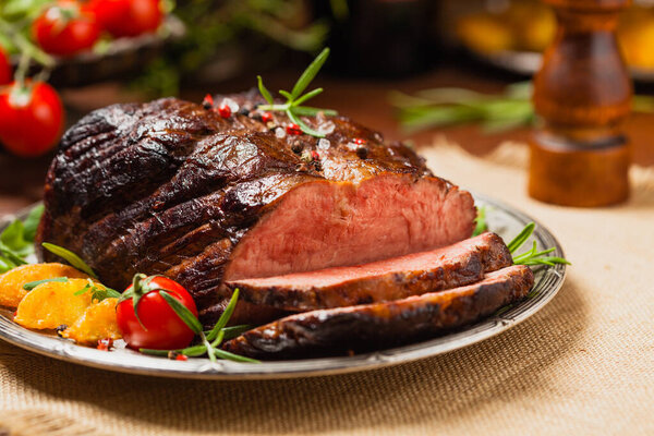 Roasted brisket. Rustic style, natural wooden background. Dark style. Front view. 