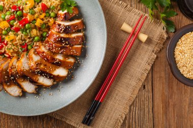 Teriyaki soslu ızgara tavuk göğsü. Kahverengi pirinç ve sebzelerle servis edilir. Üst Manzara. Düz yatıyordu.