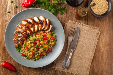 Teriyaki soslu ızgara tavuk göğsü. Kahverengi pirinç ve sebzelerle servis edilir. Üst Manzara. Düz yatıyordu.