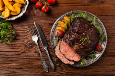 Kızarmış göğüs eti. Kırsal tarzda, doğal ahşap arka plan. Karanlık stil. Üst Manzara. Düz yatıyordu. 