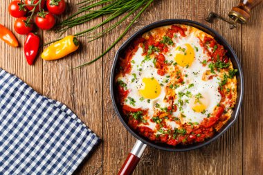 Shakshouka, domates sosunda haşlanmış yumurta, acı biber, soğan. Üst görünüm. 