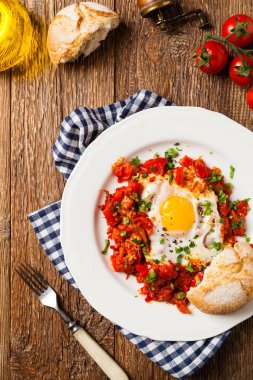 Shakshouka, domates sosunda haşlanmış yumurta, acı biber, soğan. Üst görünüm. 