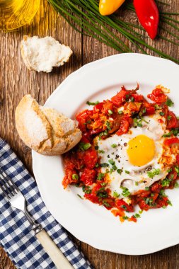 Shakshouka, domates sosunda haşlanmış yumurta, acı biber, soğan. Üst görünüm. 