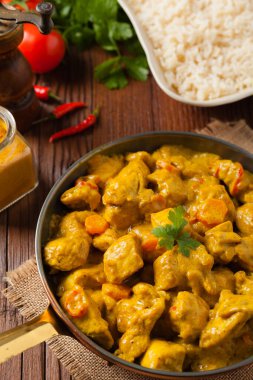 Körili tavuk sosu. Tavada servis edilmiş. Ön manzara. Doğal ahşap zemin.