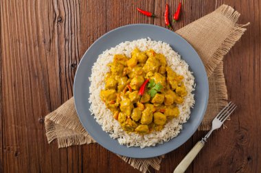 Körili tavuk sosu. Pirinçle servis edilmiş. Üst Manzara. Doğal ahşap zemin.