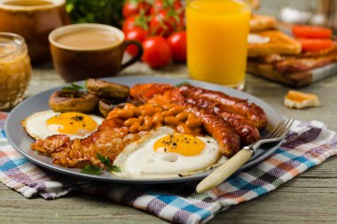 Tam İngiliz kahvaltısı, sosis, mantar, fasulye ve sahanda yumurta. Ön görünüm. 